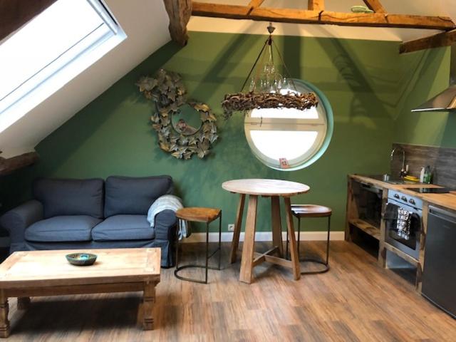 ein Wohnzimmer mit einem Sofa und einem Tisch in der Unterkunft Les Gîtes Ecosphère in Genappe