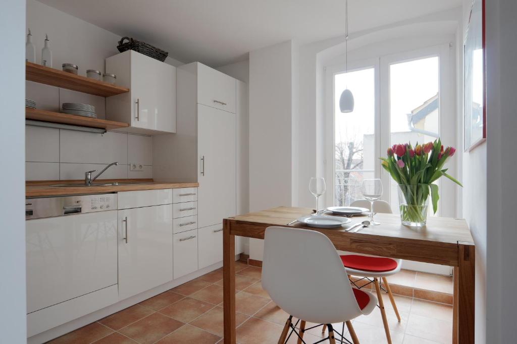 a kitchen with a wooden table and white cabinets at Zweite Heimat Heidelberg in Heidelberg