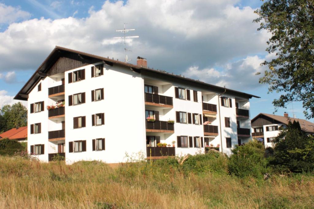 a white apartment building with a black roof at Fewo mit malerischem Bergblick im in Bischofsmais