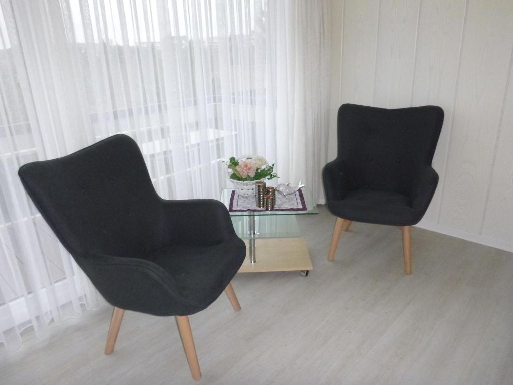 two black chairs and a table in a room at Haus Delphin in Bad Wildungen
