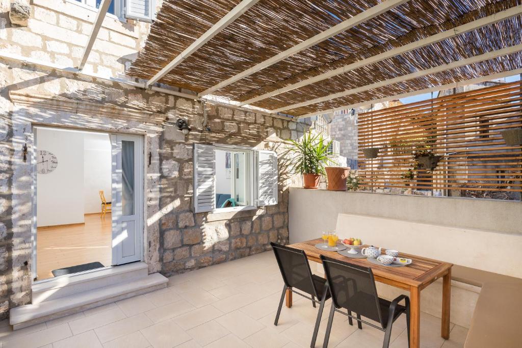 an outdoor patio with a wooden table and chairs at Apartment Coral in Dubrovnik