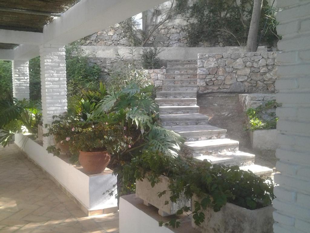 a stone wall with stairs and potted plants at villaquinta in La Herradura