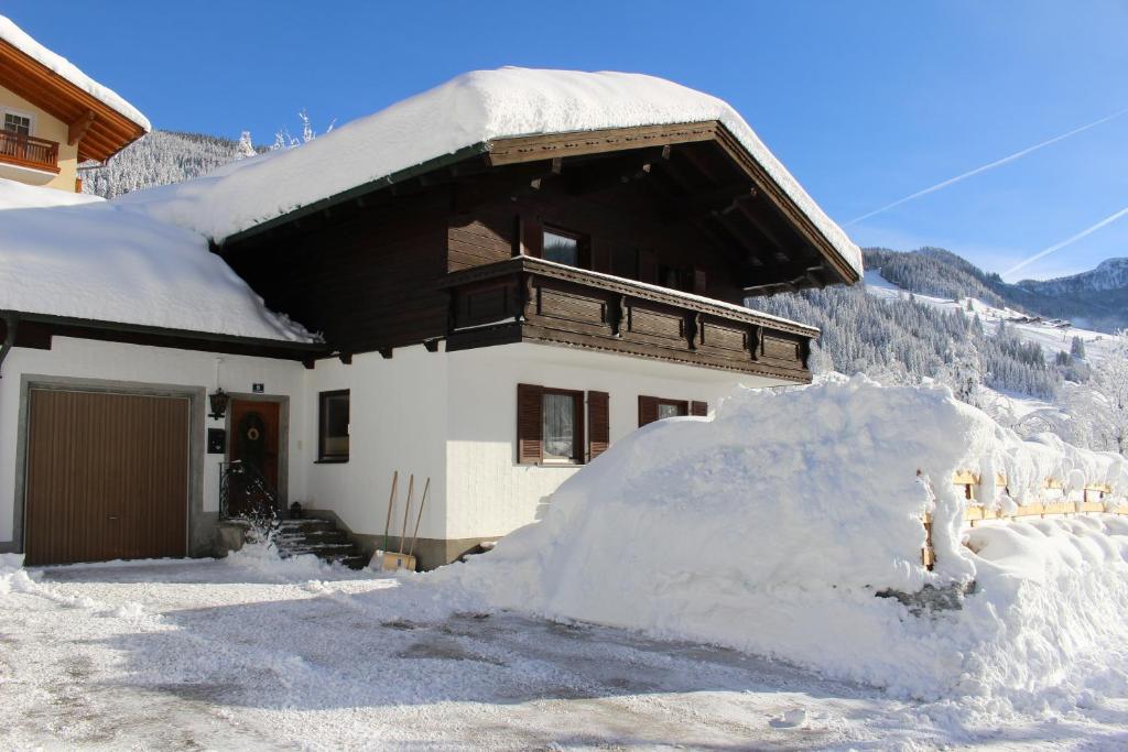 a house with a pile of snow in front of it at Ferienhaus Gschwandtl in Kleinarl