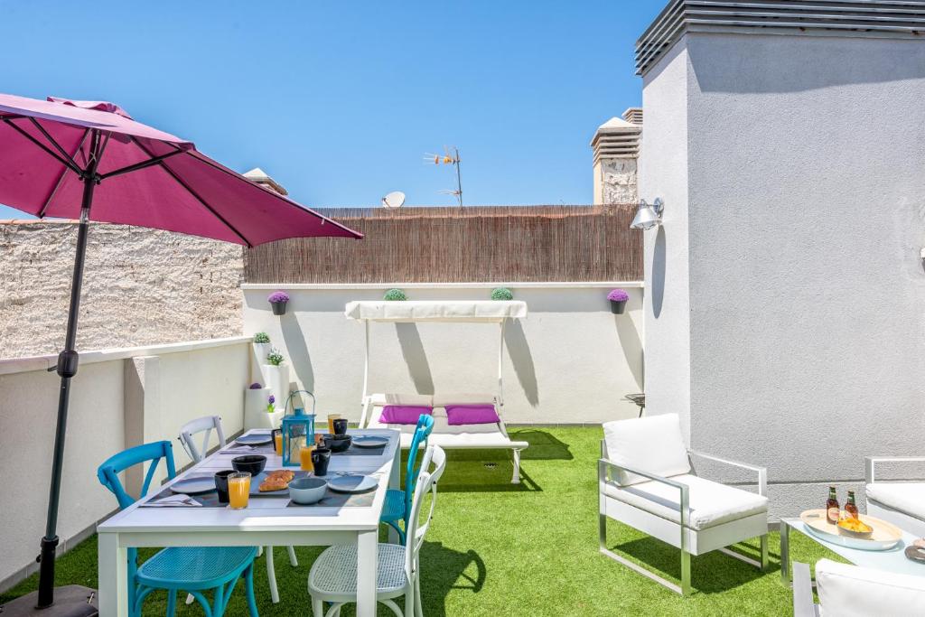 une terrasse avec une table, des chaises et un parasol dans l'établissement Atico terraza privada piscina centro ac nuevo 1hab, à Malaga