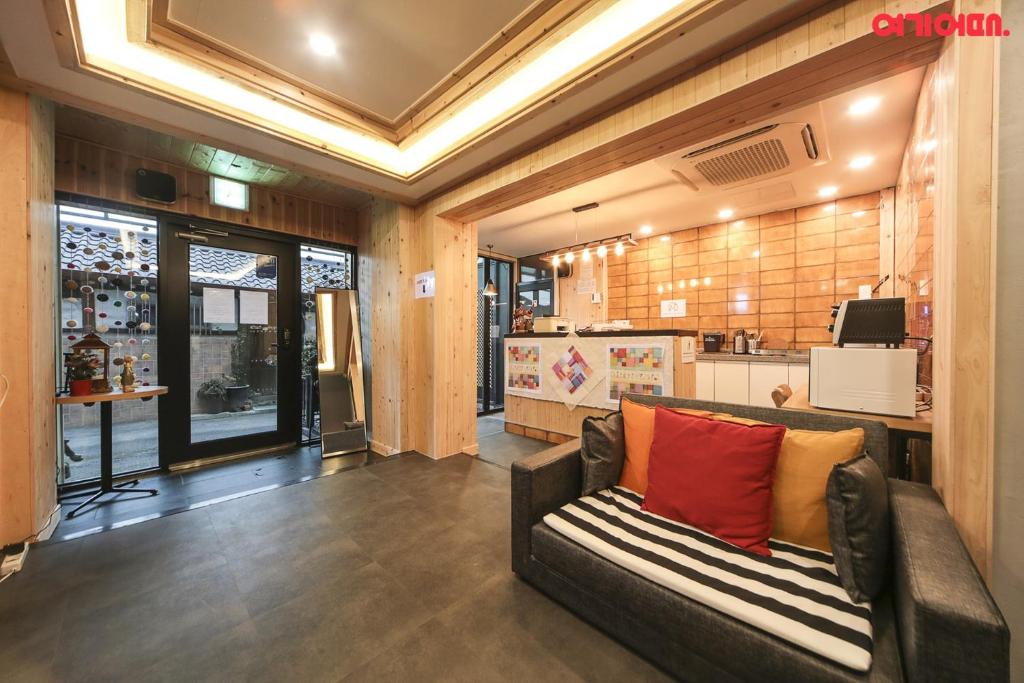 a living room with a couch and a kitchen at Insadong R Guesthouse in Seoul