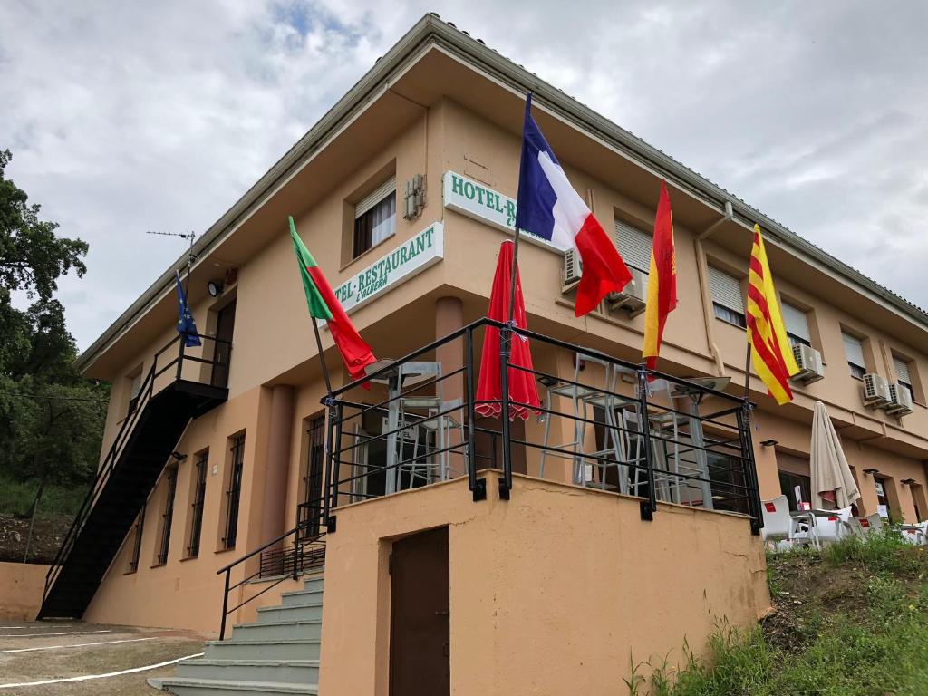 un edificio con banderas en la parte delantera en Hotel l'Albera en La Jonquera