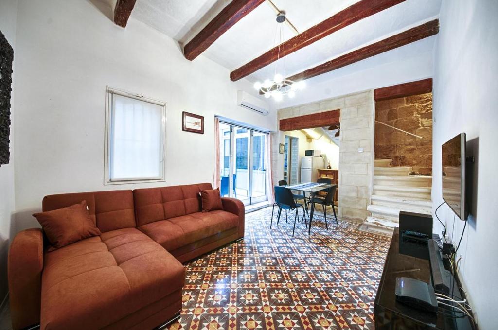 a living room with a brown couch and a fireplace at Valletta Heritage Town House in Valletta
