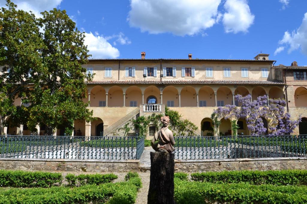 a building with a statue in front of a garden at Certosa di Pontignano Residenza d'Epoca in Ponte A Bozzone