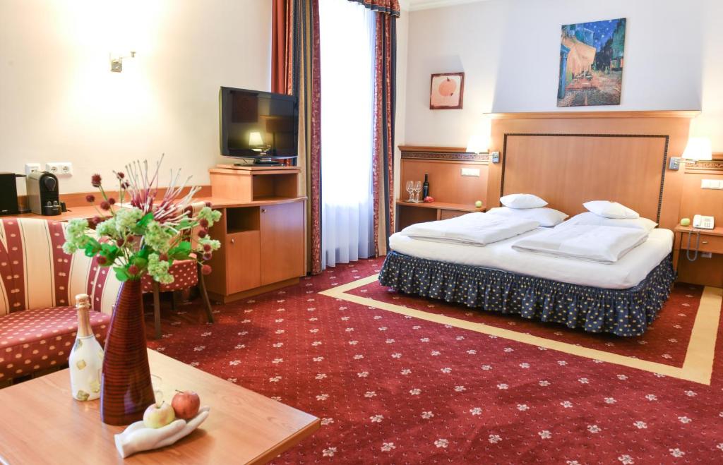 una camera d'albergo con letto e tavolo di Hotel Alexandra a Wels