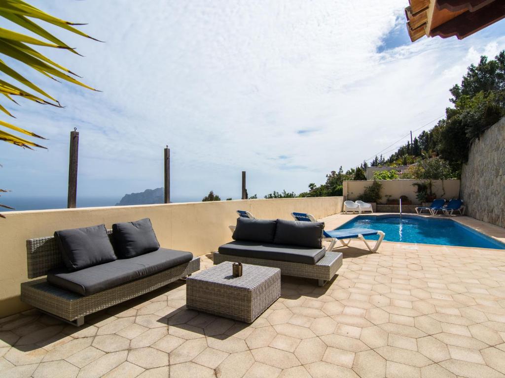 a patio with two couches and a swimming pool at Belvilla by OYO Casa Eldorado in Benissa