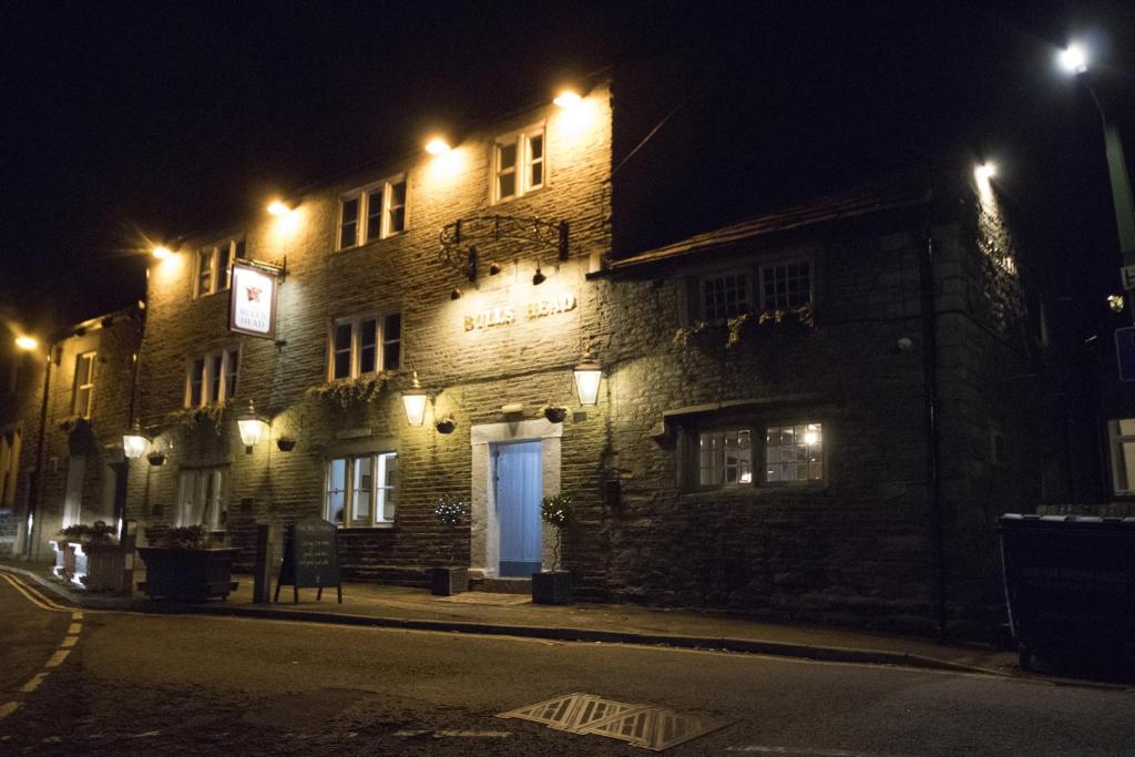 a brick building with a blue door at night at The Bulls Head in Glossop