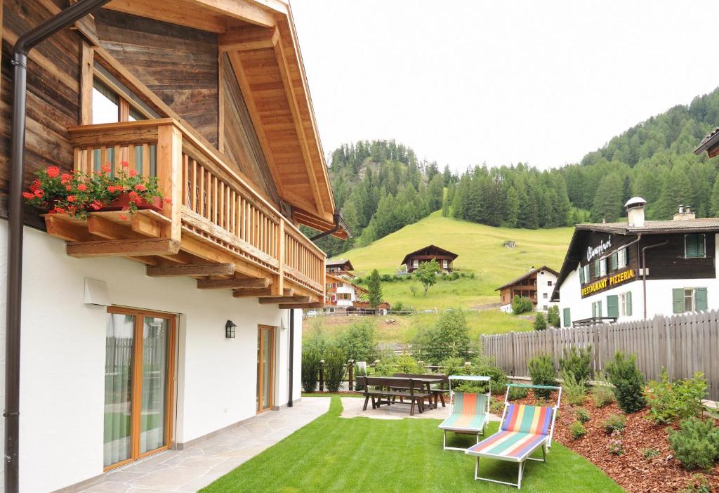 a patio with chairs and a table in a yard at Apartments Isgla in Selva di Val Gardena