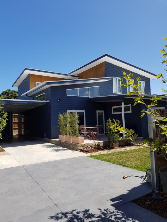 a blue house with a driveway in front of it at Zeally Bay Stay Deep Ocean in Torquay