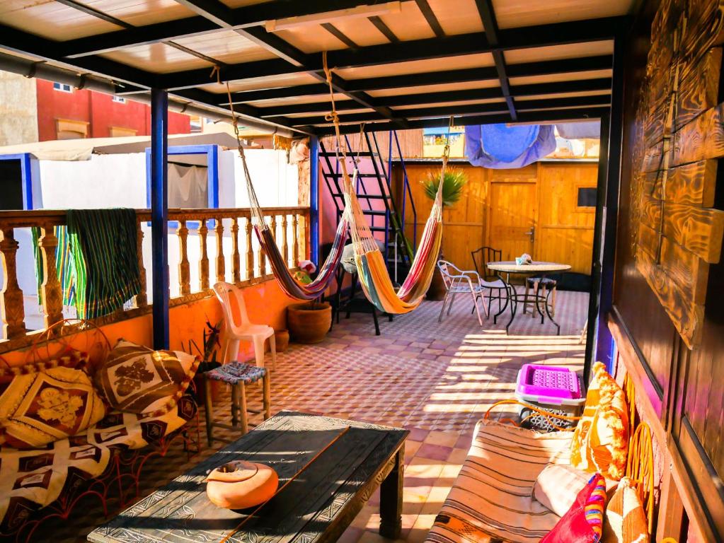 een balkon met een hangmat en een tafel en stoelen bij Surf hostel Morocco in Tamraght Ouzdar