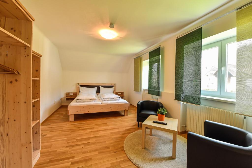 a bedroom with a bed and a desk and a chair at GÄSTEHAUS HARTL - Gasthof Hartl, vlg Zum Wirt in Neuhaus