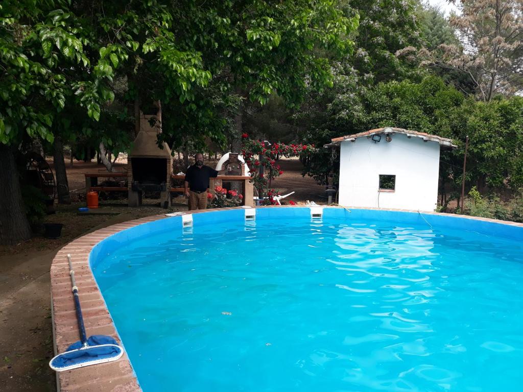 una gran piscina azul junto a un edificio blanco en Agroturismo la finka, en Los Quiles
