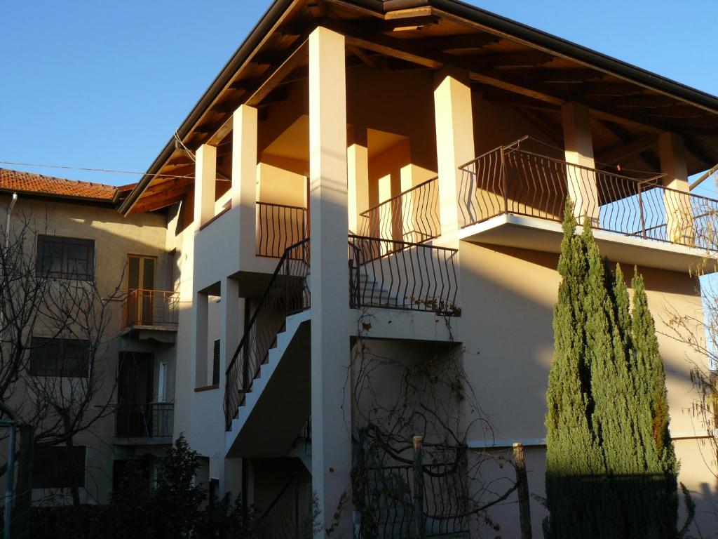 un edificio blanco con balcones y un árbol en Casa Anna, en Crosa