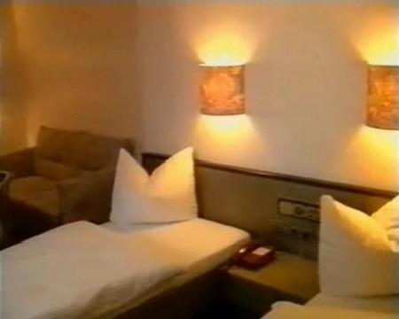 een hotelkamer met een bed en een bank bij Hotel Merkur Garni in Zwickau