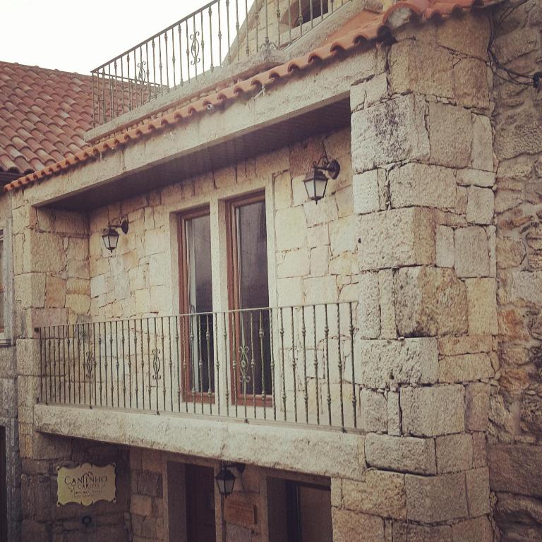 a stone building with a balcony on the side of it at Cantinho Ti Carlos in Pitões das Júnias