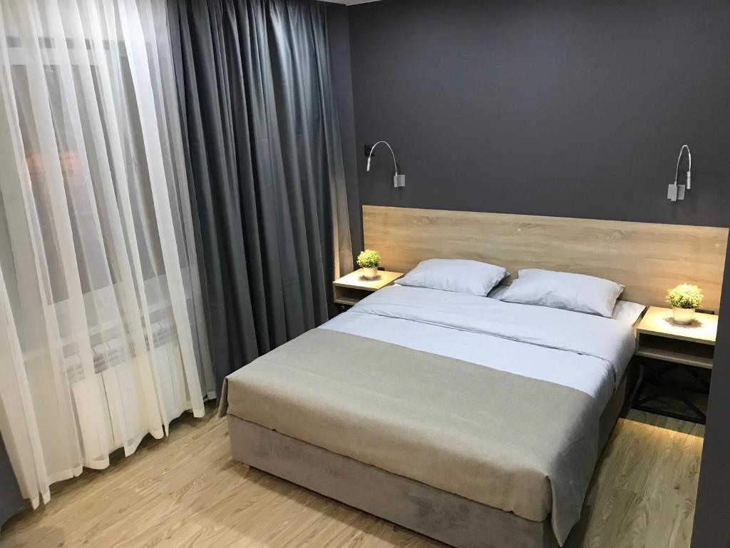 a bedroom with a large bed and two night stands at Islander Mini - Hotel in Yuzhno-Sakhalinsk