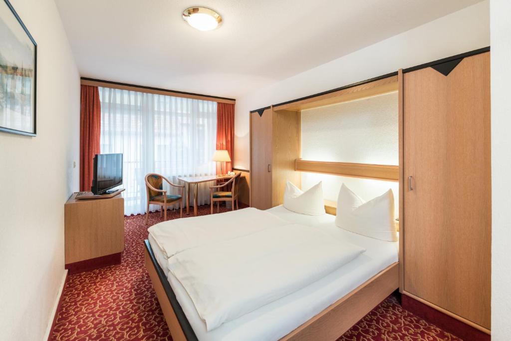 um quarto de hotel com uma cama grande e uma mesa em Hotel am Markt em Eisenach