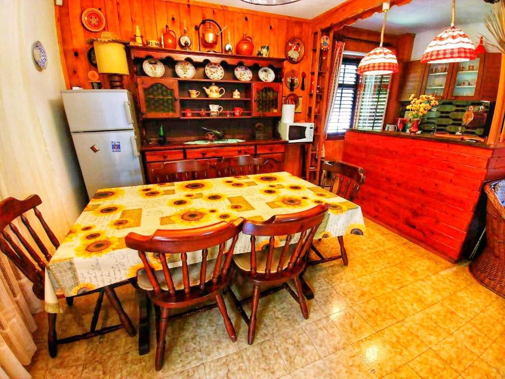 a kitchen with a table with chairs and a refrigerator at Kuća za odmor &quot;Livadica&quot; in Netretić