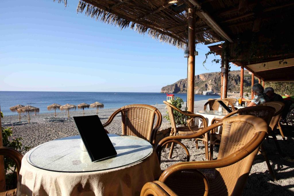 a table with a laptop on it on the beach at Santa Irene in Sougia