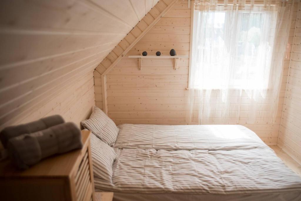 a small bedroom with a bed and a window at Jeden domek in Sztutowo