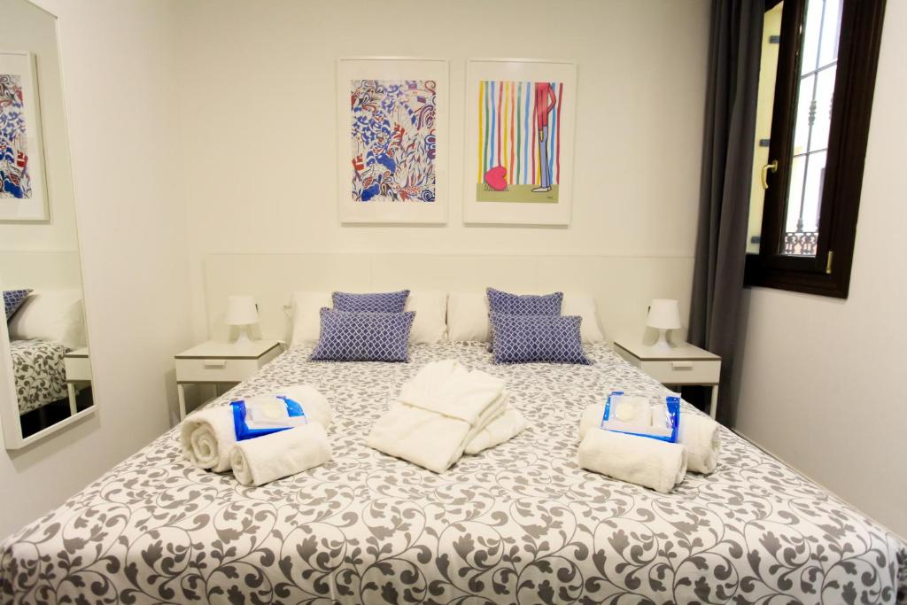 a bedroom with a large bed with blue and white pillows at Carretería Center Apartments in Málaga