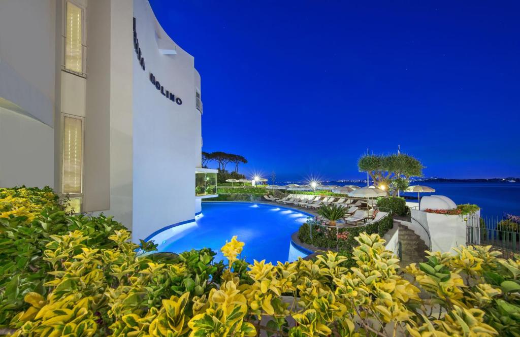 un resort con piscina di notte di Punta Molino Beach Resort & Thermal Spa a Ischia
