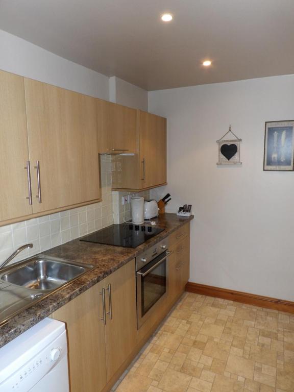 a kitchen with wooden cabinets and a sink and a counter at Broccoli Bottom in Oakham