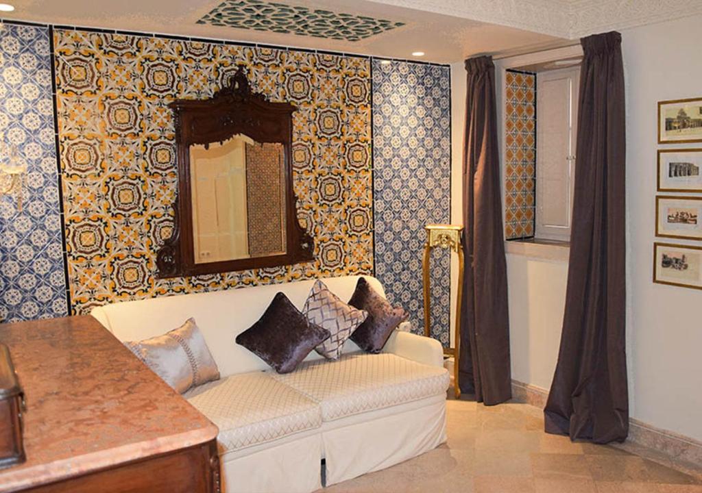 a living room with a couch and a mirror at Dar ALOUINI in Kairouan