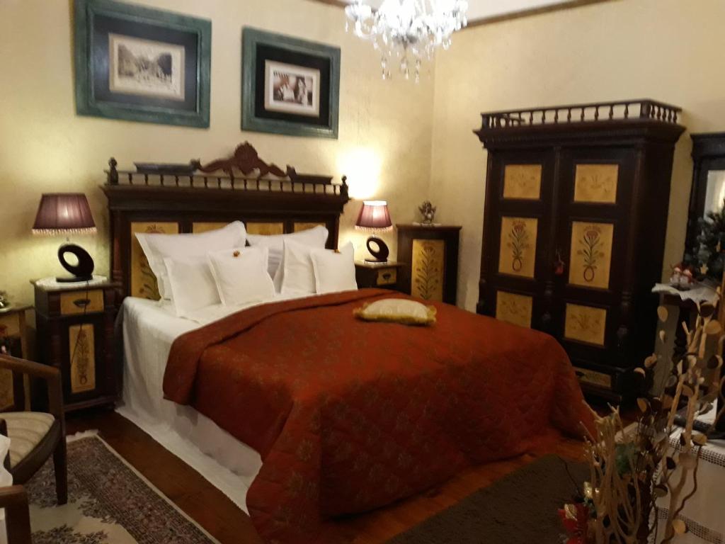 a bedroom with a large bed with a red blanket at Casa Cositorarului Boutique Pension in Sighişoara