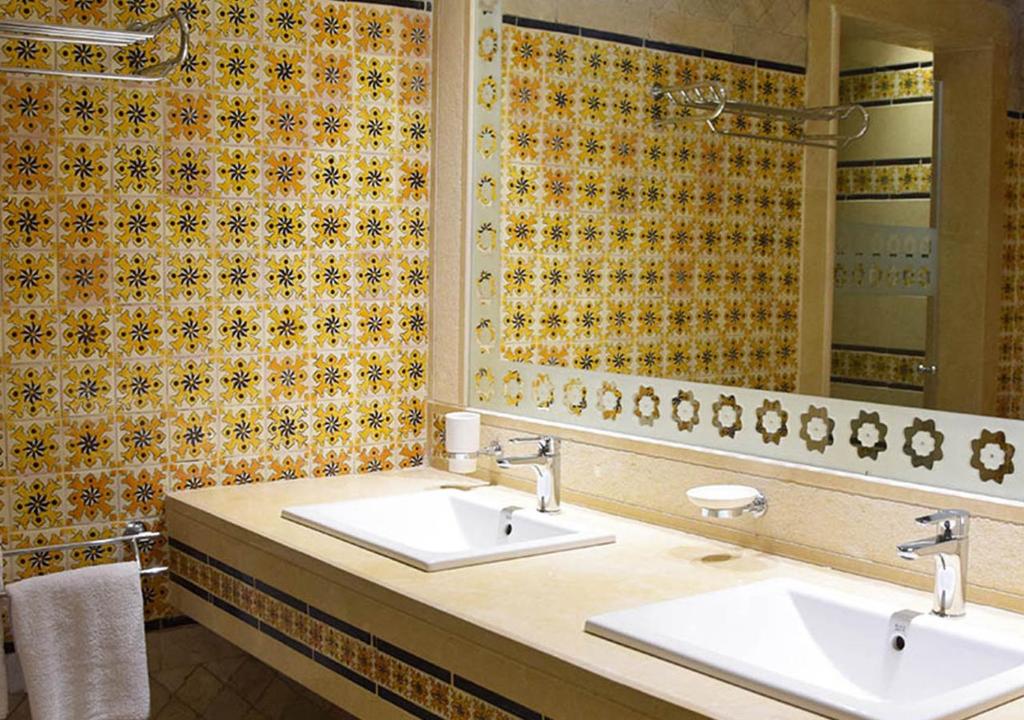 a bathroom with two sinks and a mirror at Dar ALOUINI in Kairouan