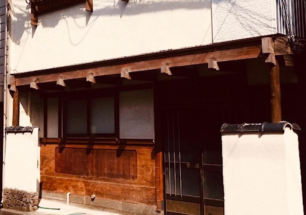 新潟市にあるゲストハウス　アンゴ荘の木製の扉付きの建物の入口