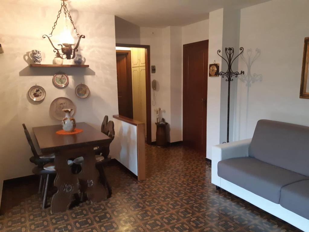 uma sala de estar com um sofá e uma mesa em Appartamento Limone con vista em Limone Piemonte