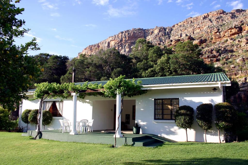 a white house with a mountain in the background at Kunje Guesthouse in Op-die-Berg