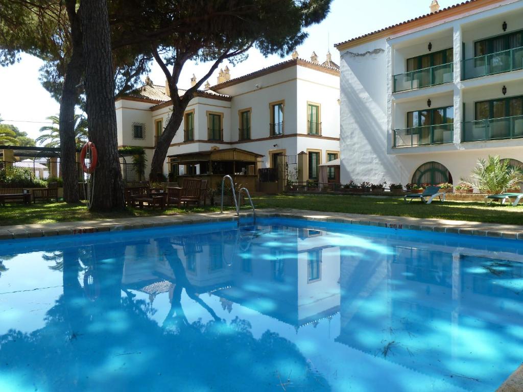 una gran piscina frente a un edificio en Hotel Oromana, en Alcalá de Guadaira