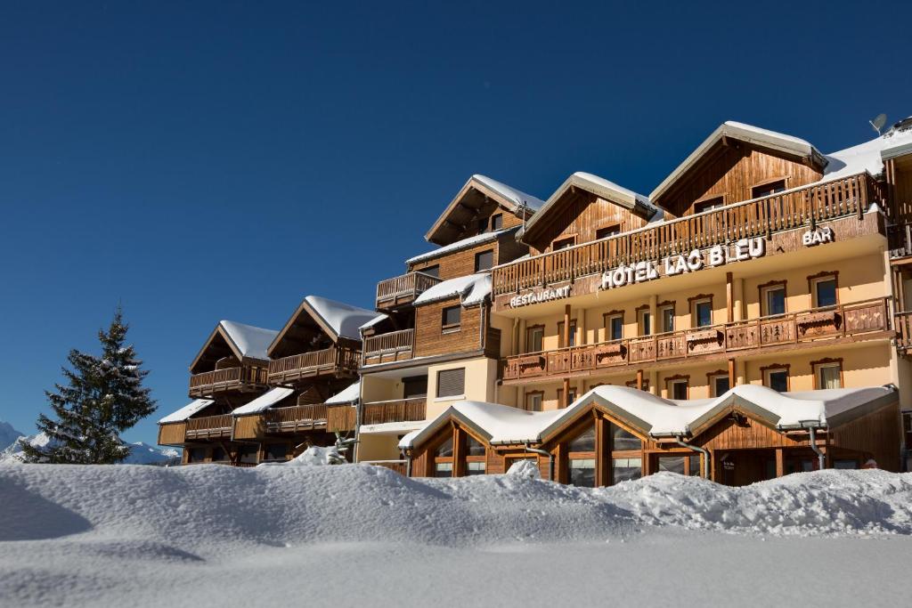 a hotel in the snow with a pile of snow at Hotel Lac Bleu 1650 in Saint-François-Longchamp