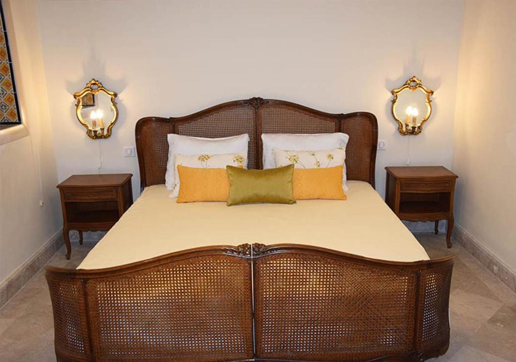 a wicker bed with pillows on it in a bedroom at Dar ALOUINI in Kairouan