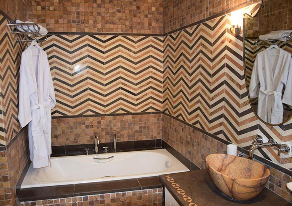 a bathroom with a bath tub and a sink at Dar ALOUINI in Kairouan