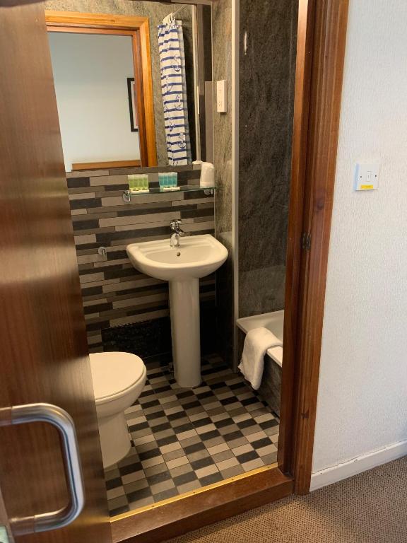 a bathroom with a sink and a toilet at London Visitors Hotel in London