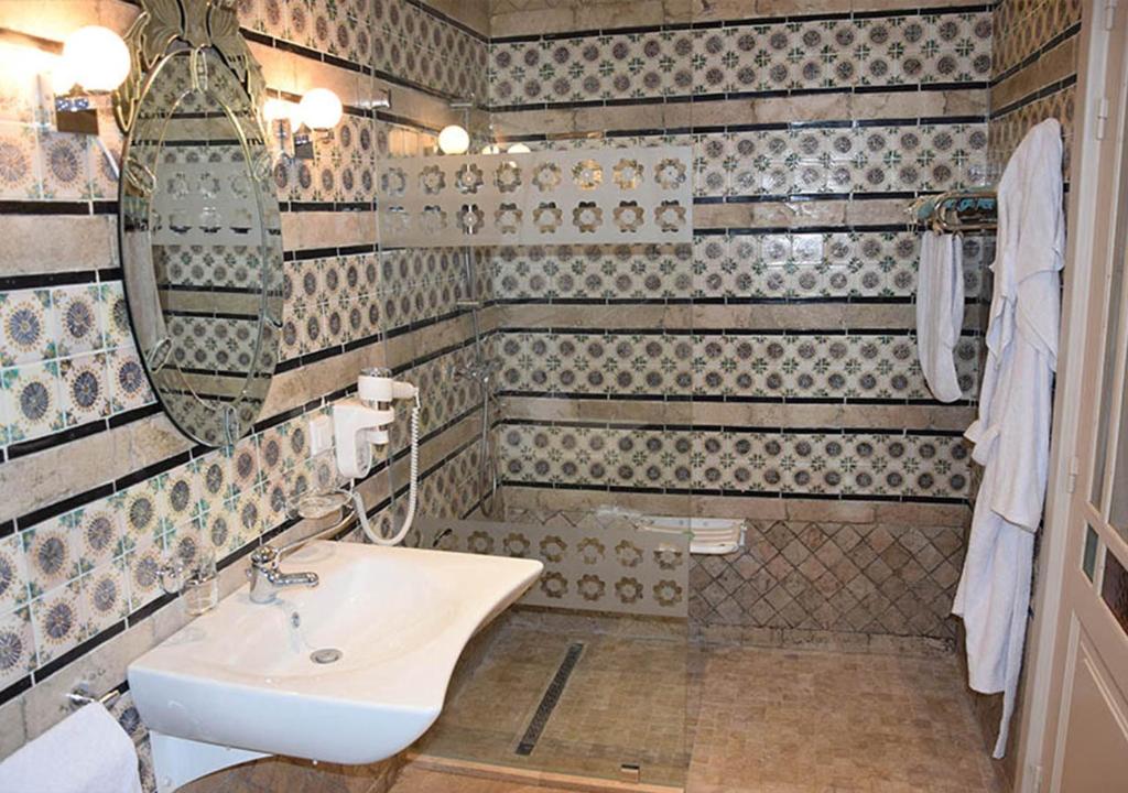 a bathroom with a sink and a mirror at Dar ALOUINI in Kairouan