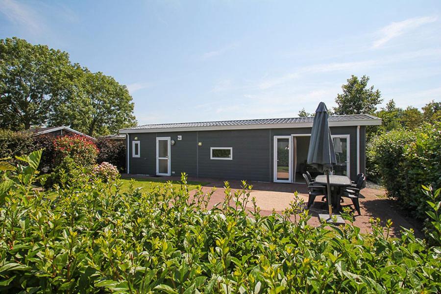 een zwart huis met een paraplu in een tuin bij Holiday rentals in Velsen-Zuid