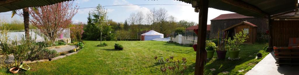 a view of a yard with a tent in the background at yourtes du bocage in Bazoges-en-Pareds