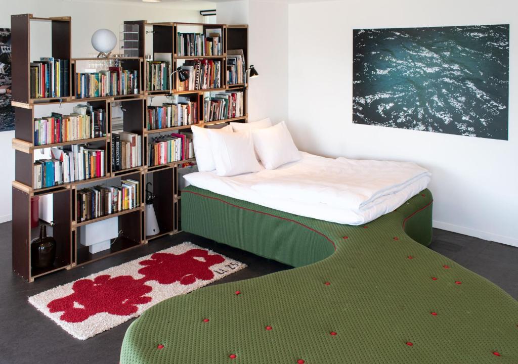 um quarto com uma cama e uma estante de livros com livros em SWEETS - Sluis Haveneiland em Amsterdã