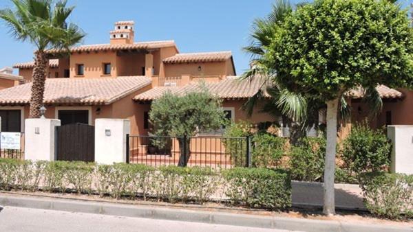 ein großes Haus mit einem Zaun davor in der Unterkunft HL025 Luxury 3 bedroom villa with community pool in Fuente Alamo