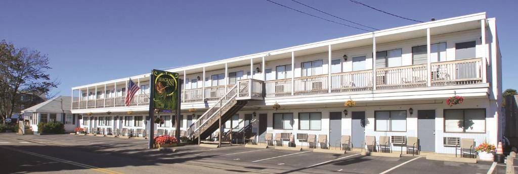 a large white building with a staircase in front of it at Seagrass Inn in Old Orchard Beach