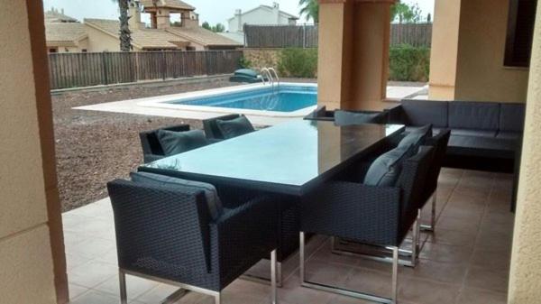 HL003 Luxury 3 Bedroom Detached villa with Private pool في Fuente Alamo: طاولة وكراسي مع مسبح في الخلفية