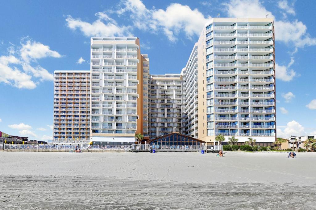 dois edifícios altos em frente a uma praia com condomínios em Sands Ocean Club em Myrtle Beach